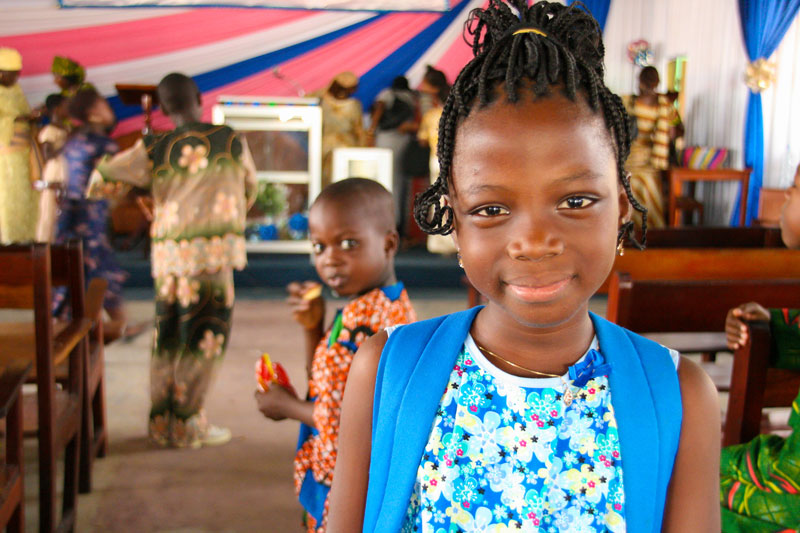 Smiling girl standing in a church sancuary in Benin